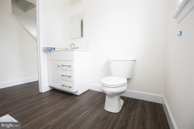 bathroom with vanity, toilet, and hardwood / wood-style flooring