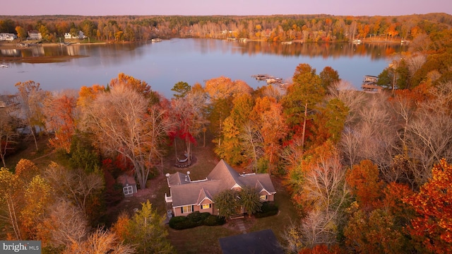 aerial view at dusk featuring a water view