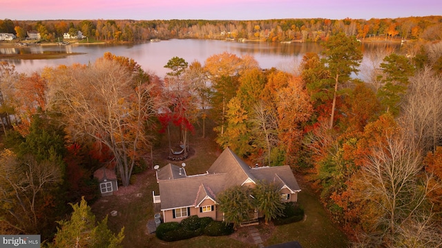 aerial view at dusk featuring a water view