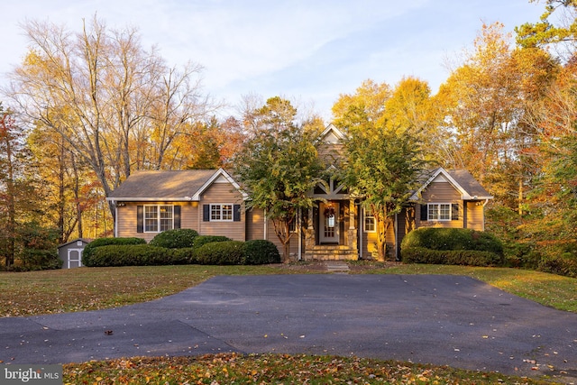 view of front of home featuring a shed and a porch