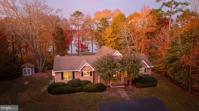 view of front of property featuring a porch and a storage shed