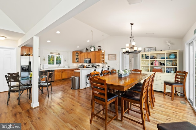 dining room with lofted ceiling, sink, a notable chandelier, and light wood-type flooring