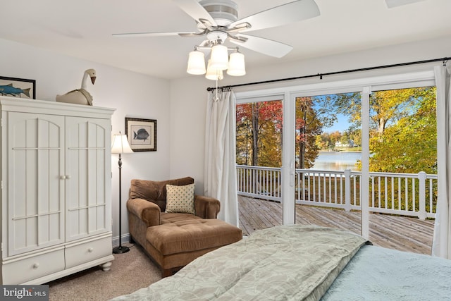 carpeted bedroom with a water view, ceiling fan, and access to exterior