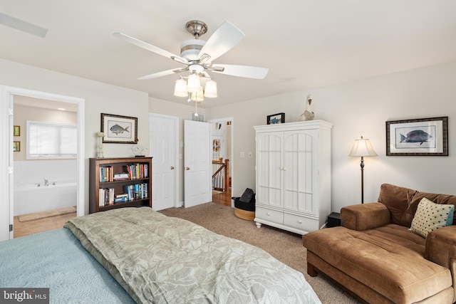 carpeted bedroom featuring ceiling fan and ensuite bath