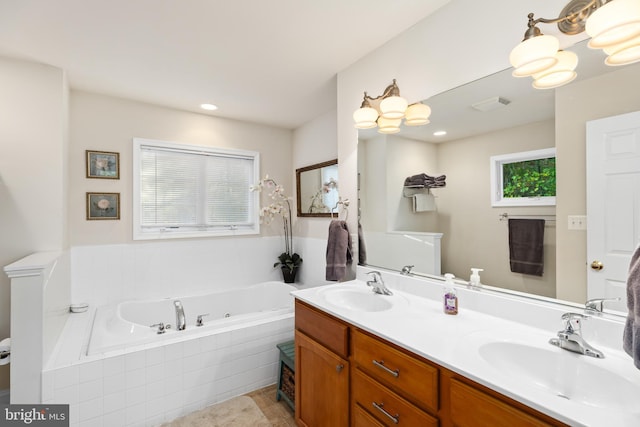 bathroom with vanity and a relaxing tiled tub