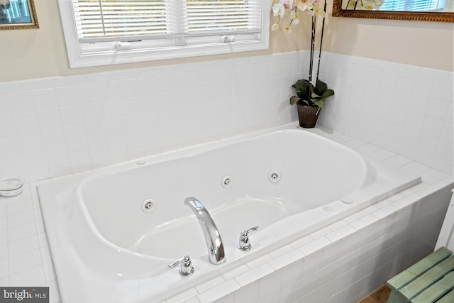 bathroom with tiled tub and plenty of natural light