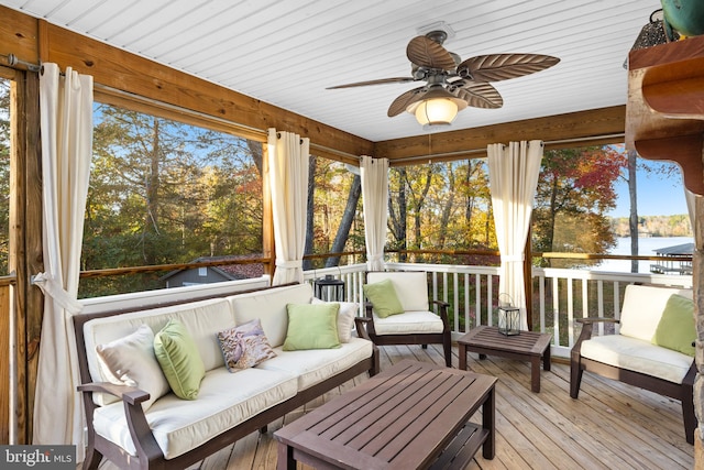 sunroom / solarium featuring a water view and ceiling fan