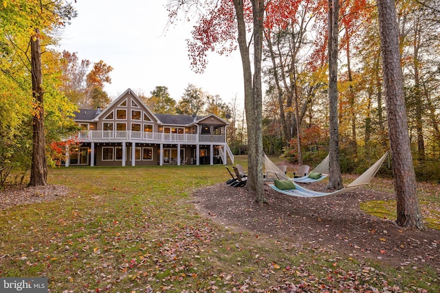 back of property with a yard and a deck