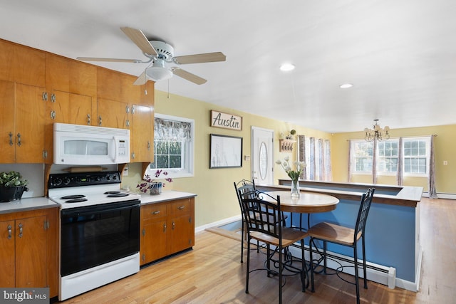 kitchen featuring white appliances, light hardwood / wood-style flooring, plenty of natural light, and a baseboard heating unit