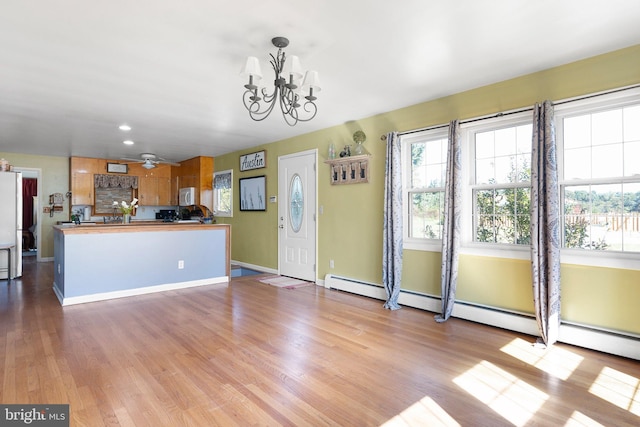 kitchen featuring light wood-type flooring and ceiling fan with notable chandelier