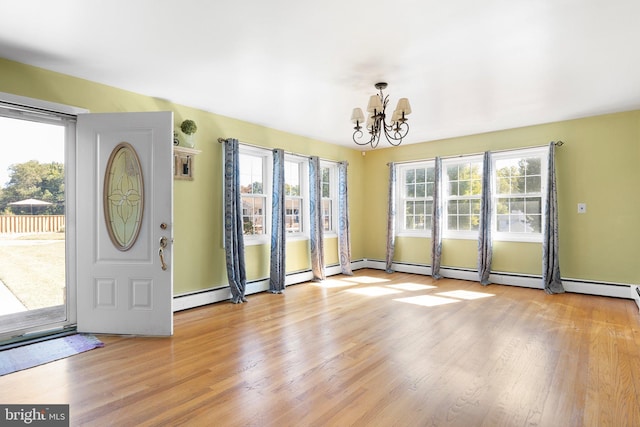 entrance foyer with light hardwood / wood-style floors, an inviting chandelier, and a healthy amount of sunlight