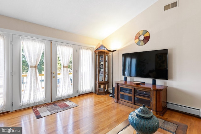 living room with french doors, lofted ceiling, a baseboard radiator, and hardwood / wood-style floors