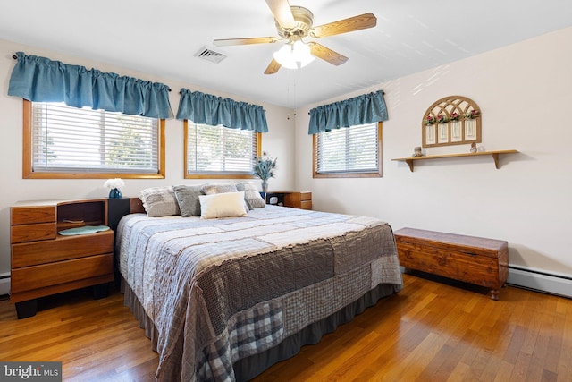 bedroom featuring a baseboard radiator, wood-type flooring, and ceiling fan