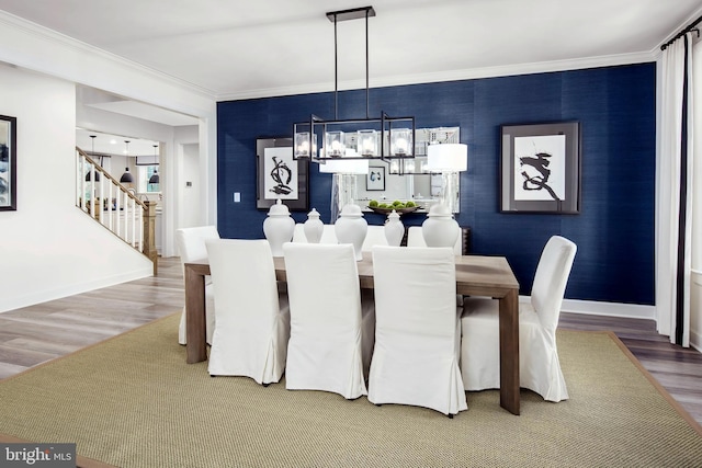 dining space with a chandelier, crown molding, and hardwood / wood-style flooring