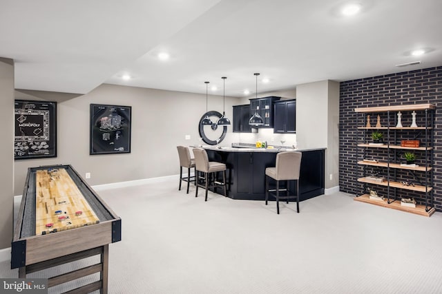 bar featuring light carpet, blue cabinetry, and hanging light fixtures