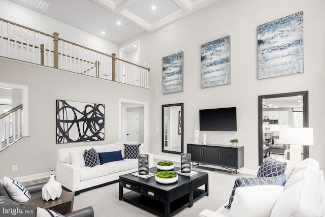 living room featuring beamed ceiling, coffered ceiling, light carpet, and a towering ceiling