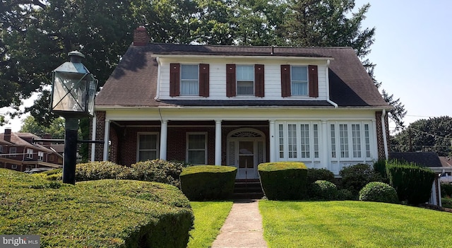 view of front facade with covered porch and a front lawn