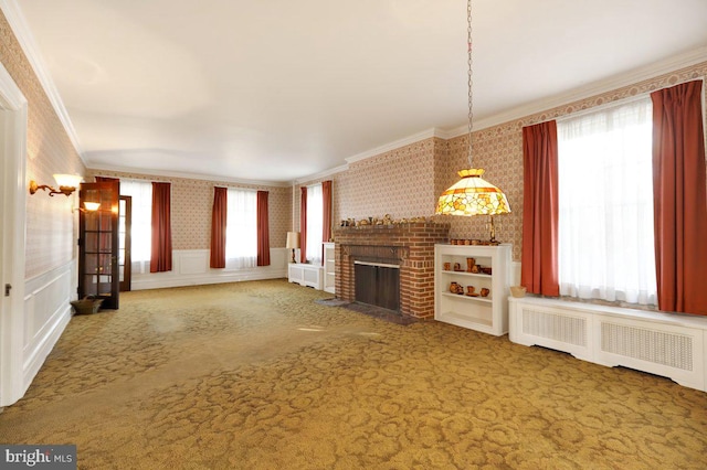 unfurnished living room featuring carpet, crown molding, radiator heating unit, and a healthy amount of sunlight