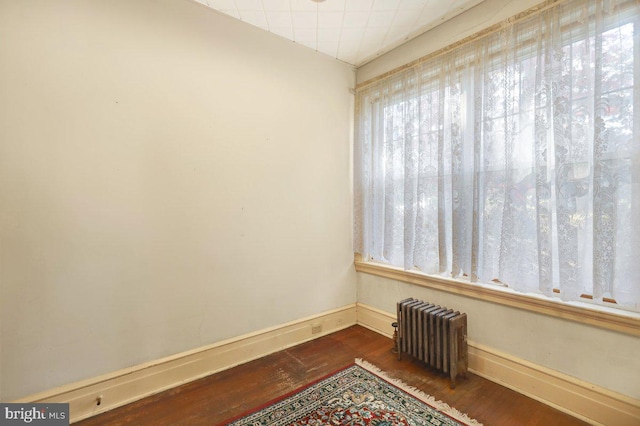 empty room featuring dark hardwood / wood-style floors and radiator