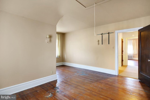 spare room with wood-type flooring and radiator heating unit