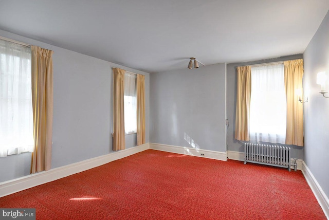 empty room with radiator heating unit and carpet floors