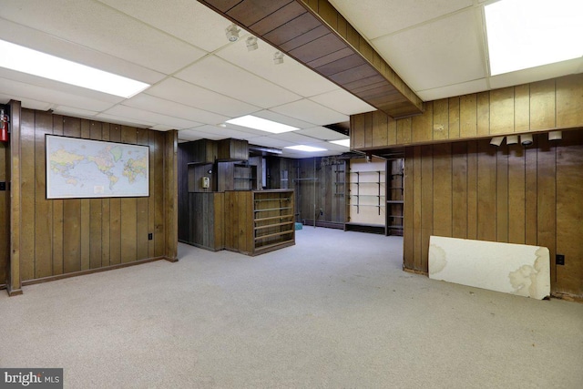 basement featuring wooden walls and light colored carpet