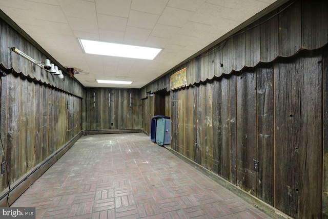 basement with a baseboard radiator and wood walls