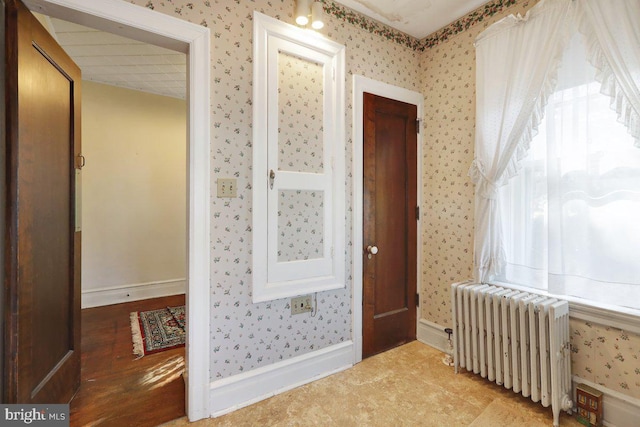 hallway featuring radiator heating unit and wood-type flooring