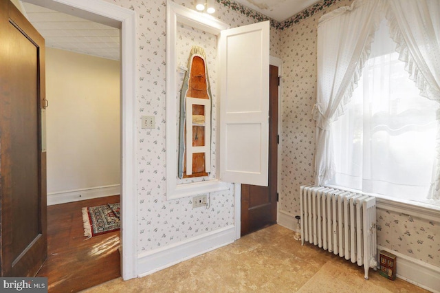 hallway featuring radiator heating unit and light wood-type flooring