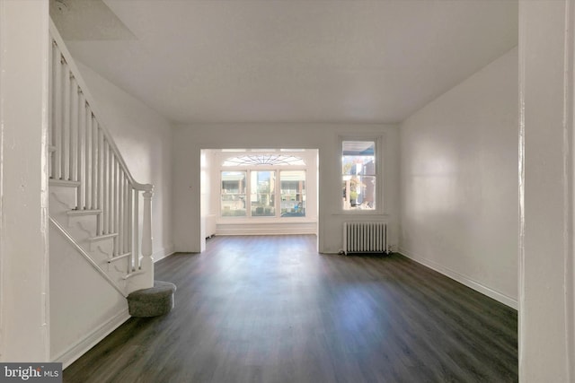 unfurnished living room featuring dark wood-type flooring and radiator