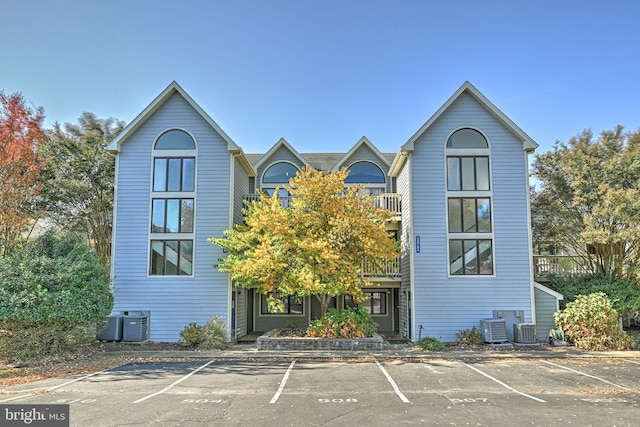 view of front of house with central air condition unit and a balcony