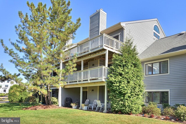 rear view of property featuring a lawn