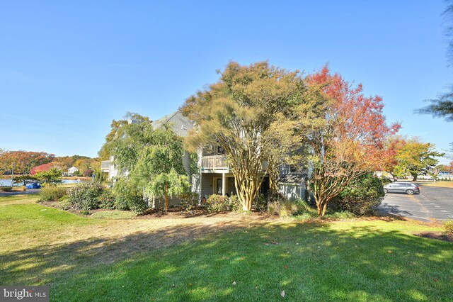 view of front of home featuring a balcony and a front yard