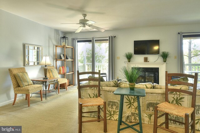 living room featuring light carpet, a healthy amount of sunlight, and ceiling fan