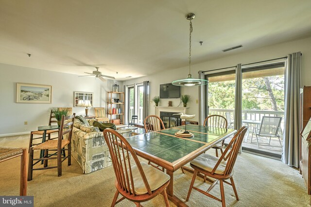 dining area with light carpet and ceiling fan