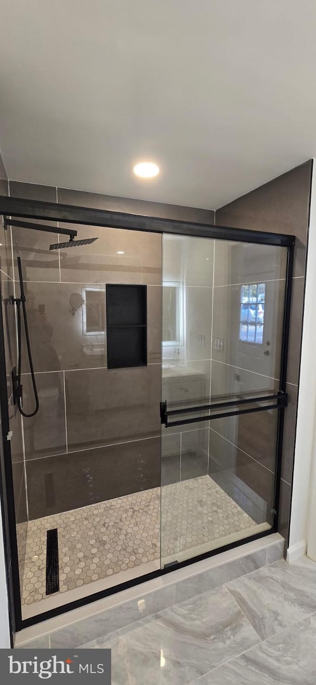 bathroom featuring a shower with door