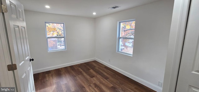 empty room with plenty of natural light and dark hardwood / wood-style floors