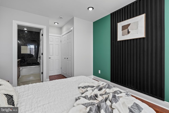 bedroom featuring a closet, ensuite bathroom, and wood-type flooring