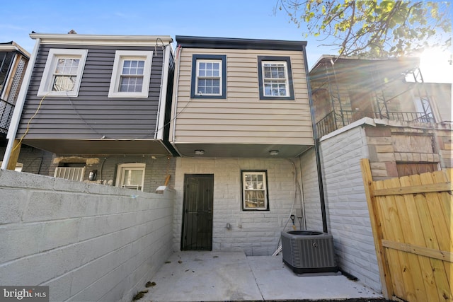 back of house featuring a balcony, central air condition unit, and a patio area