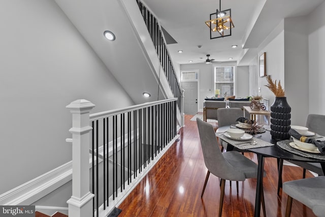 hall with dark wood-type flooring and an inviting chandelier