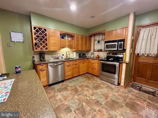 kitchen featuring appliances with stainless steel finishes, decorative backsplash, and sink