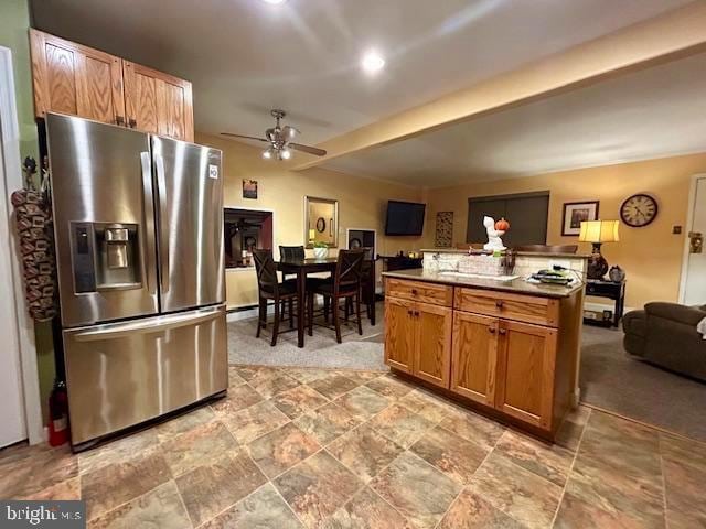 kitchen featuring stainless steel fridge, a center island, and ceiling fan