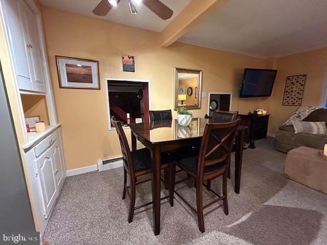 carpeted dining area with baseboard heating, beamed ceiling, and ceiling fan