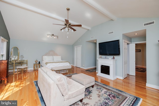 living room with light hardwood / wood-style floors, lofted ceiling with beams, and ceiling fan