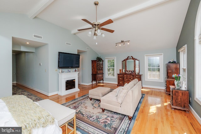 living room with beamed ceiling, high vaulted ceiling, light wood-type flooring, and ceiling fan