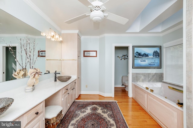 bathroom with hardwood / wood-style flooring, a tub, toilet, crown molding, and vanity