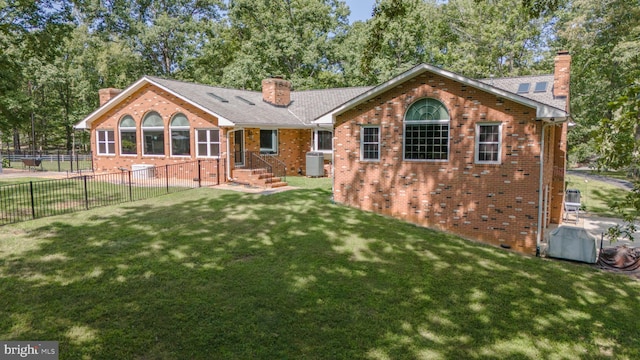 back of property featuring a lawn and central AC unit