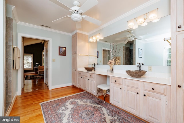 bathroom featuring vanity, ornamental molding, hardwood / wood-style flooring, and ceiling fan