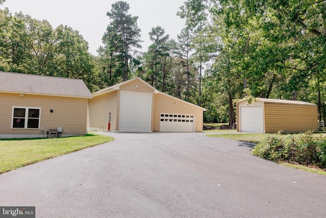 view of front facade with a front yard, an outdoor structure, and a garage