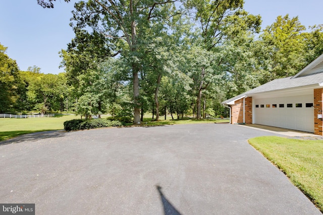 view of home's exterior with a garage and a lawn